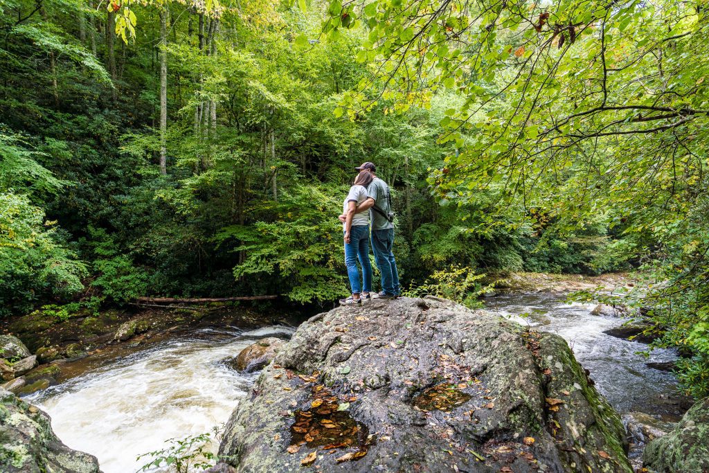 Couple looking at Cullasaja Falls' upper section in the NC Smoky Mountains