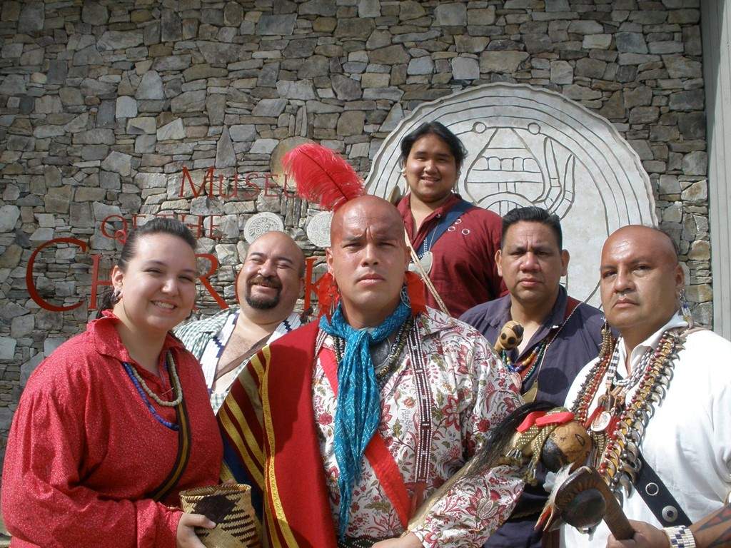 Cherokee people stand in front of their history museum