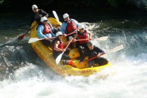 People going down a rapid on a whitewater rafting tour with the Nantahala Outdoor Center in NC.